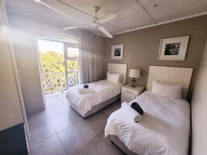 爱德华港Caribbean Estates-Montego Bay 12的一间带两张床的卧室和一个阳台