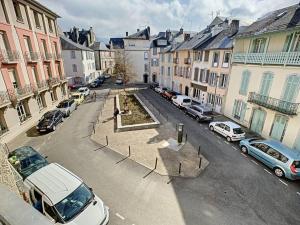 巴涅尔德比戈尔[L'ABBAT-JOUR] L'émeraude • Plein Sud • Thermes的一条城市街道,有停车的汽车和建筑