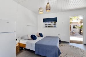 克拉伦代克The Hut Bonaire的一间卧室配有一张带蓝色枕头的床。
