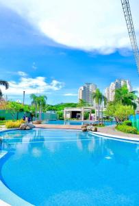 马尼拉Your Crib - kasara -19 D tower 1的一个大型蓝色游泳池,其建筑背景为: