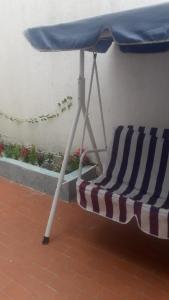 圣玛尔塔Casa Amplia Completa Privada para Familias的露台的遮阳伞下的沙滩椅