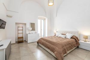 奥斯图尼Le Bianche Suites Ostuni的白色卧室配有一张大床和一张书桌