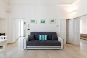奥斯图尼Le Bianche Suites Ostuni的白色的客厅配有蓝色的沙发