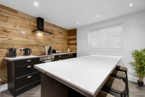 利物浦Harrow Lodge - Anfield Apartments的厨房设有木墙和白色台面