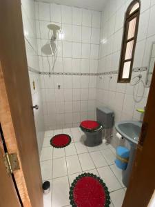 卡拉瓜塔图巴Recanto mato verde的浴室设有卫生间,地板上铺有红色垫子。