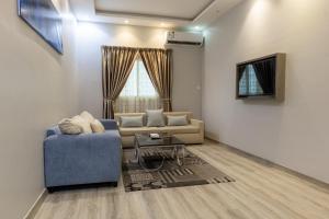 麦地那Modern Family Apartments 7 Mins Drive to Al Masjid Nabwi - Al Jamawat的客厅配有蓝色的沙发和电视