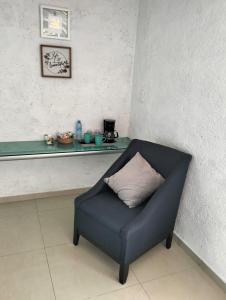 科苏梅尔Hotel Dos Mundos, Isla Cozumel的一张蓝色椅子和枕头,坐在房间里