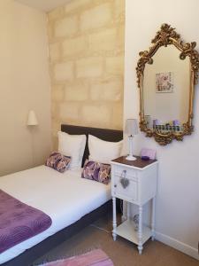 波尔多LA SALAMANDRE的一间卧室配有一张带镜子和桌子的床