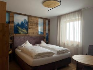 塞尔瓦迪加尔代纳山谷A Sosta的一间卧室配有带白色枕头的床