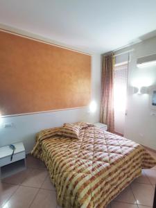 格罗塞托依尔派克酒店的一间卧室配有一张带大床头板的床