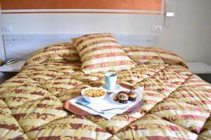 格罗塞托依尔派克酒店的一张带甜甜圈托盘和食物托盘的床