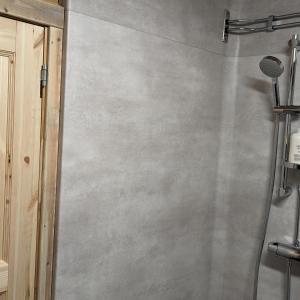 Vittangi KapellLapland Snow Moose的浴室设有混凝土墙,配有淋浴