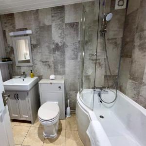 萨克斯曼德姆斯伯顿白马酒店的浴室配有卫生间、浴缸和水槽。