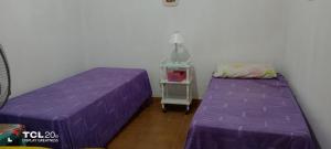 阿尔玛菲埃尔特Hospedaje LA LUCIA的紫色床单的客房内的两张床