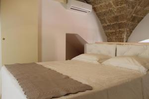 卡萨拉诺B&B Nino Moro的卧室配有白色床和石质天花板
