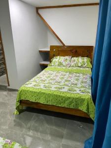 圣安德烈斯Casas Manatwar`s的一间卧室配有一张带绿色棉被的床