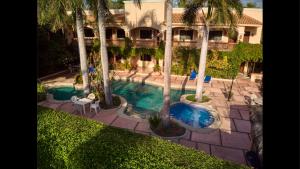 罗斯巴利勒斯Los Barriles Hotel的享有棕榈树游泳池的顶部景致