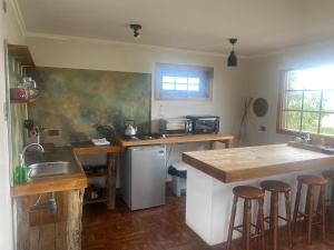 纳塔列斯港Dorotea Vista的厨房配有水槽和带酒吧凳的台面。