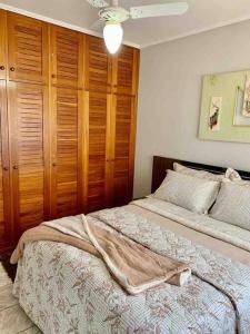 卡庞达卡诺阿Apartamento 2 quadras do mar centro Capão da Canoa的一间卧室设有两张床和木制橱柜
