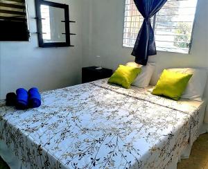 拉利伯塔德COSTA AZUL Apartment的一间卧室配有蓝色和黄色枕头的床