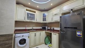 亚历山大Welcome sea view - families only的厨房配有白色橱柜、洗衣机和烘干机