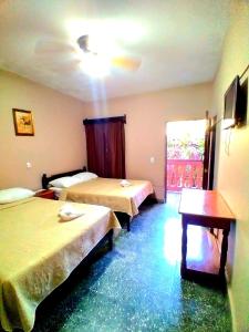 科潘玛雅遗址Hotel Rosalila的酒店客房设有两张床和一张桌子。