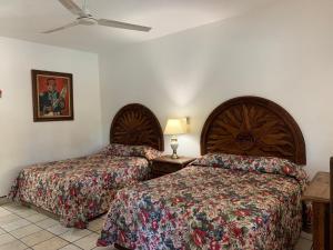 罗斯巴利勒斯Los Barriles Hotel的酒店客房配有两张床和吊扇。