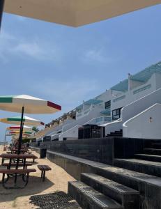 杜拉特阿拉尔غرفة صالة بلكونة على الشاطئ - عوائل的海滩上一座带楼梯和遮阳伞的建筑
