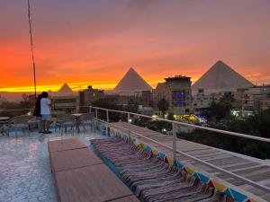 开罗Matto Pyramids Inn的站在一个望着金字塔的阳台上的女人