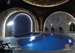 久姆里Shiraz Plaza Hotel & Spa的一座带拱门的建筑里的大型游泳池