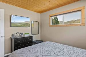 大熊湖Base Camp New Ski Slope Views with HOT TUB.的一间卧室配有一张床、镜子和窗户