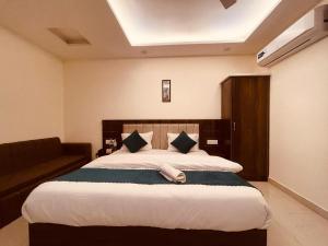 哈里瓦Wooib Hotels, Haridwar的一间卧室配有一张大床和一张沙发