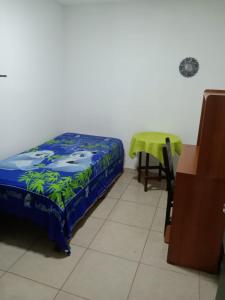 亚美尼亚Casa de Huéspedes en Armenia Quindío, Colombia的小房间设有一张床和一张桌子