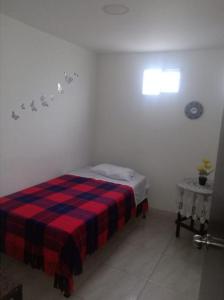亚美尼亚Casa de Huéspedes en Armenia Quindío, Colombia的一间卧室配有一张带红色和蓝色毯子的床