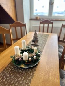 博兹达尔Apartmán U Tří smrků的木桌上的圣诞中心饰物,带蜡烛