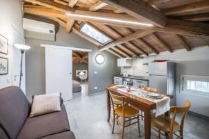 摩德纳La Casa di Valeria - Modena的厨房以及带桌椅的起居室。