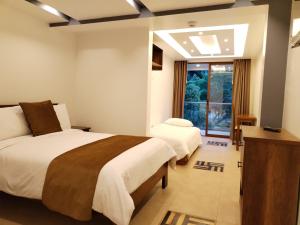 巴尼奥斯Airos Hotel的一间卧室设有两张床和窗户。