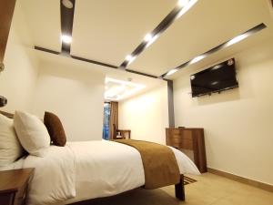 巴尼奥斯Airos Hotel的一间卧室配有一张床和一台平面电视