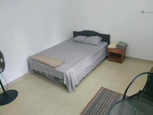 苏瓦Barrett Accommodation Rooms的一间小卧室,配有床和床头柜