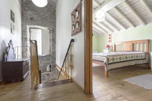 七城Casa dos Platanos-Family Home的石墙客房的卧室配有一张床