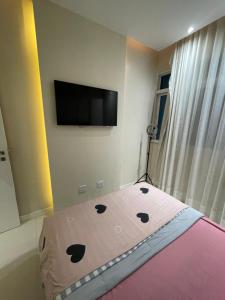 里约热内卢Apartamento Copacabana Luxo的一间卧室配有一张床和一台平面电视