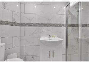 阿斯科特Modern Deluxe 3 Bedroom Flat的白色的浴室设有水槽和淋浴。