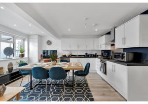 阿斯科特Modern Deluxe 3 Bedroom Flat的厨房配有桌子和蓝色椅子