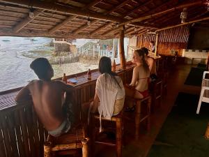 莫阿尔博阿Sunnyside Moalboal Guest house - 써니사이드 모알보알 게스트하우스的一群人坐在酒吧里看着水面