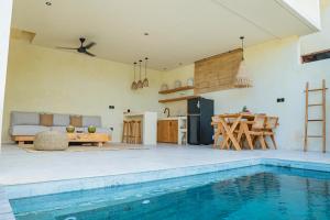 龙目岛库塔Olea Villas Resort的厨房以及带游泳池的起居室。