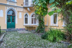 布拉索夫亚希公寓 的黄色的房子,有绿色的门和石头车道
