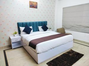 新德里Hotel Soft Petal Residency - Delhi Airport的一间卧室配有一张大床和蓝色床头板