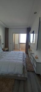 阿加迪尔Appartement 5 etoiles agadir vue mer的白色卧室设有一张大床和镜子