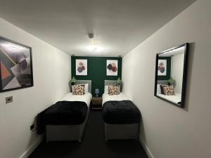 彼得伯勒Newark House Premium Apartments by DH ApartHotels的小房间设有两张床和两面镜子