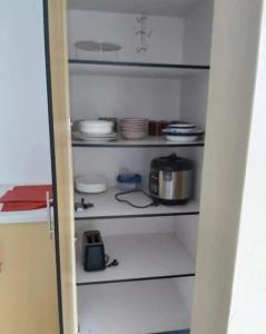 苏瓦Barrett Accommodation Budget Rooms的厨房厨房配有带餐具的白色架子